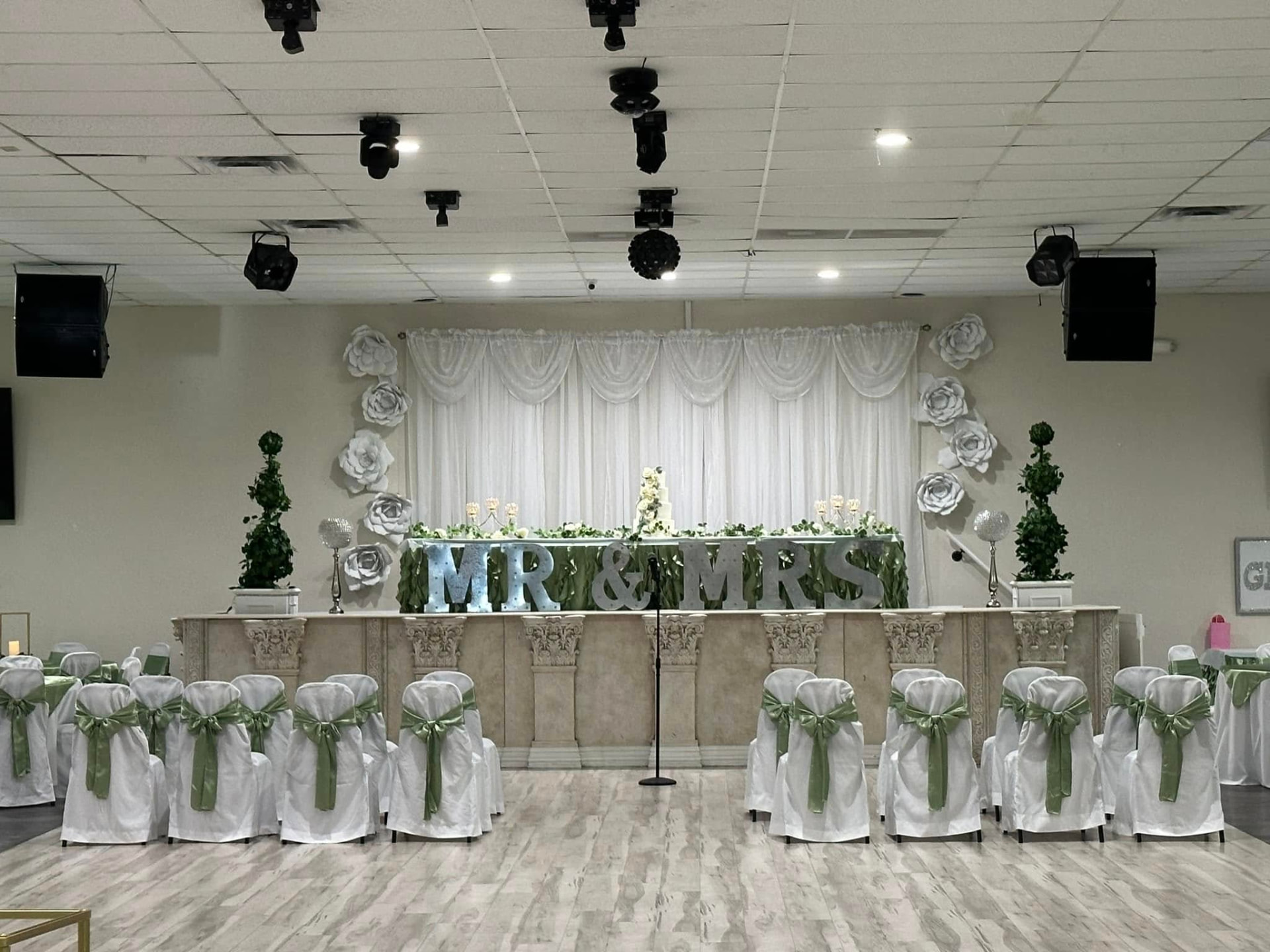 The main EPMPOA Memorial Hall venue with a raised stage and rows of chairs facing the dance floor